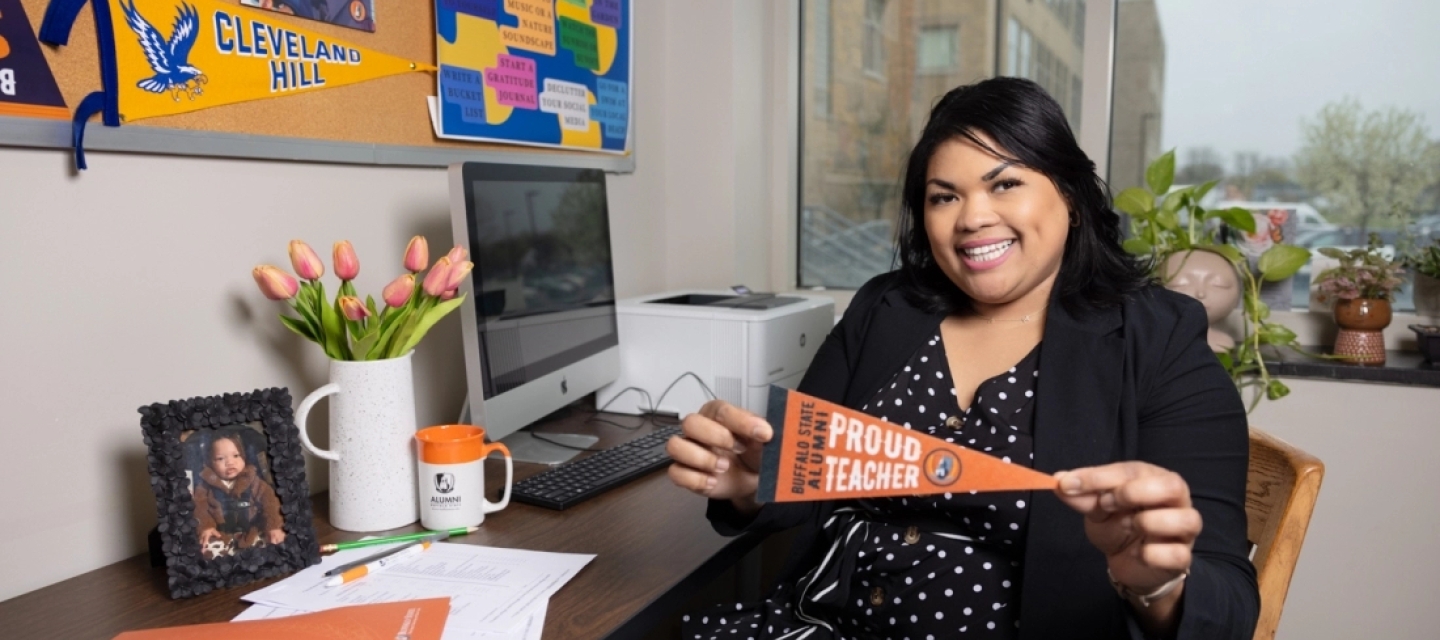 Brianna Ware holding a Buffalo State flag